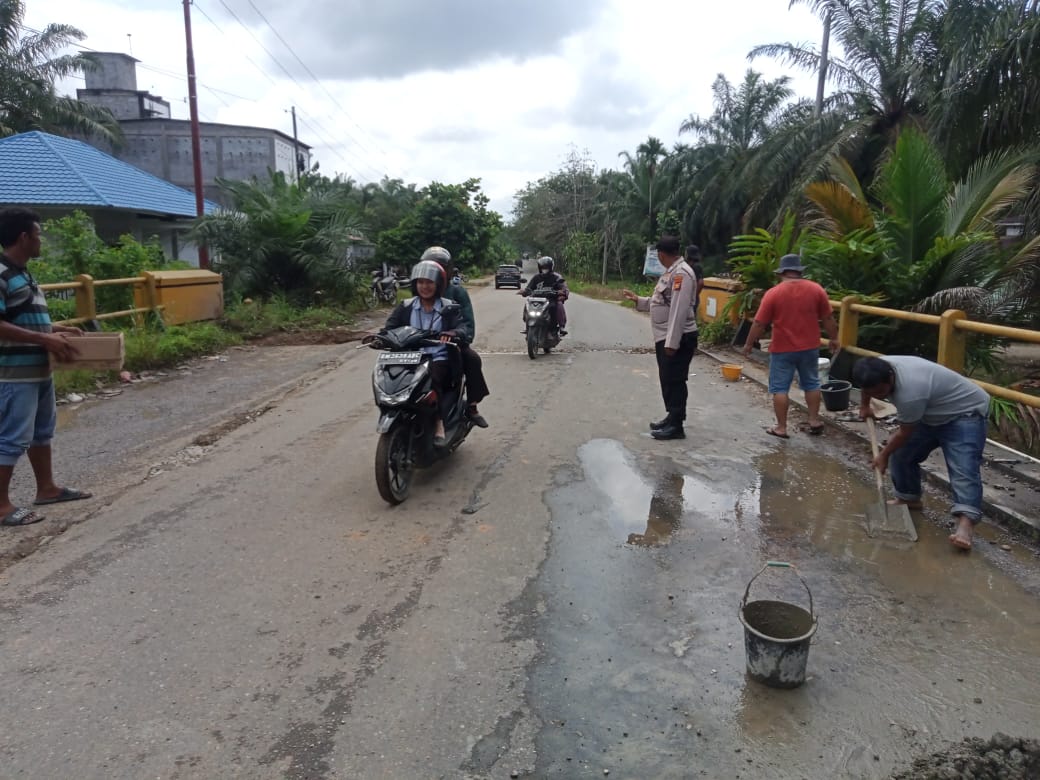 Cegah Lakalantas, Personil Polsek Rambah Hilir Gatur Lalin Dan Bantu Warga Timbun Jalan Berlobang  Di Jembatan Kumu Baru Desa Rambah