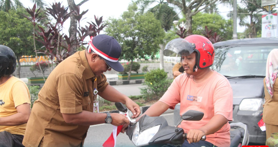Pemkab Rohul Semarakkan HUT RI ke 79 Bagikan Bendera Merah Putih Pada Pengendara di Jalan Bundaran Ratik Togak
